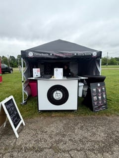 The Throw It Back Dirty Soda tent set up at an outdoor event